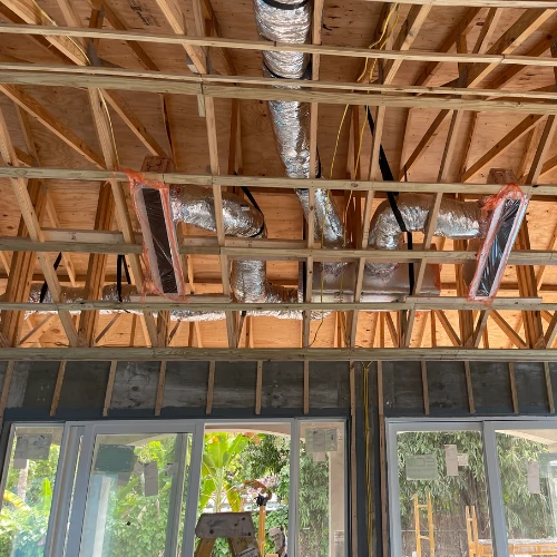 Flexible HVAC air ducts and vents installed in the ceiling wooden framing during a residential AC installation process in Fort Lauderdale.